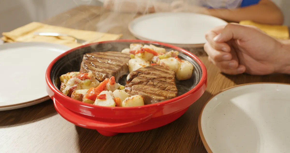 Rocket Chef pan with grilled steak and potatoes served at a dinner table